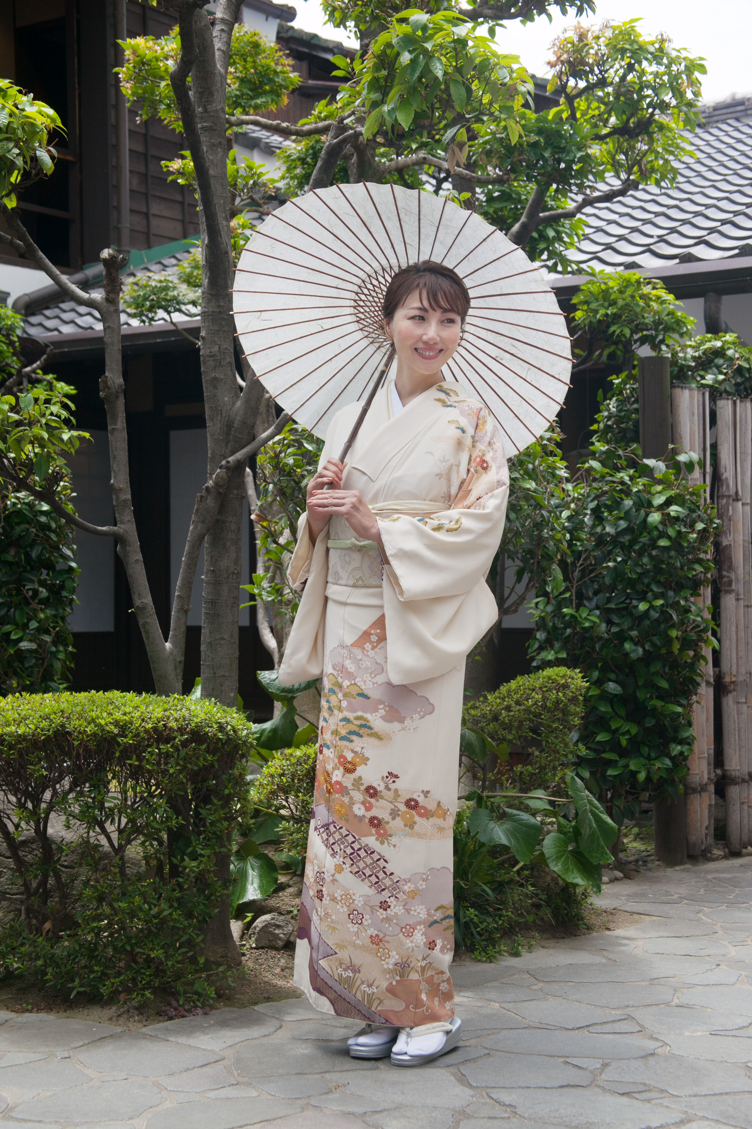 訪問着姿で番傘を差す女性